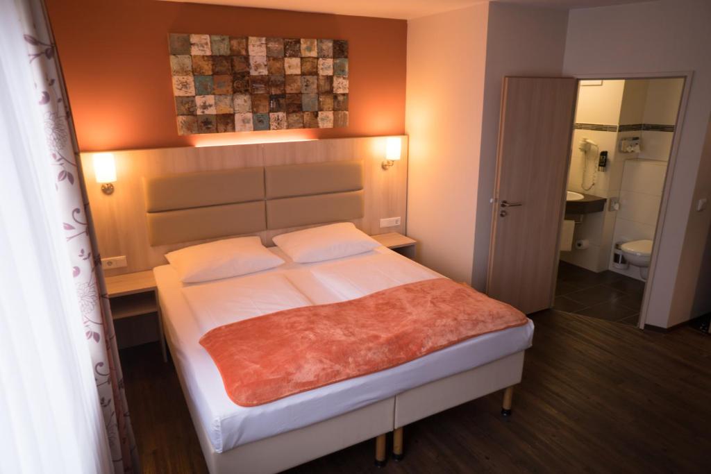 Postel nebo postele na pokoji v ubytování Hotel Rödelheimer Hof - Am Wasserturm