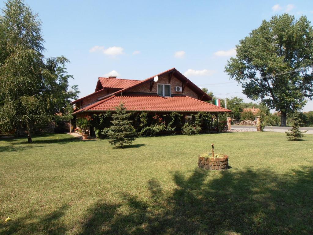 una casa con un patio verde con una casa en Pálya Vendégház, en Pusztaszer