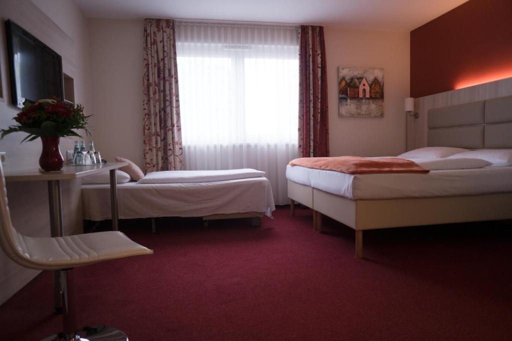 Postel nebo postele na pokoji v ubytování Hotel Rödelheimer Hof - Am Wasserturm