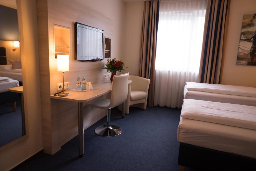 Postel nebo postele na pokoji v ubytování Hotel Rödelheimer Hof - Am Wasserturm