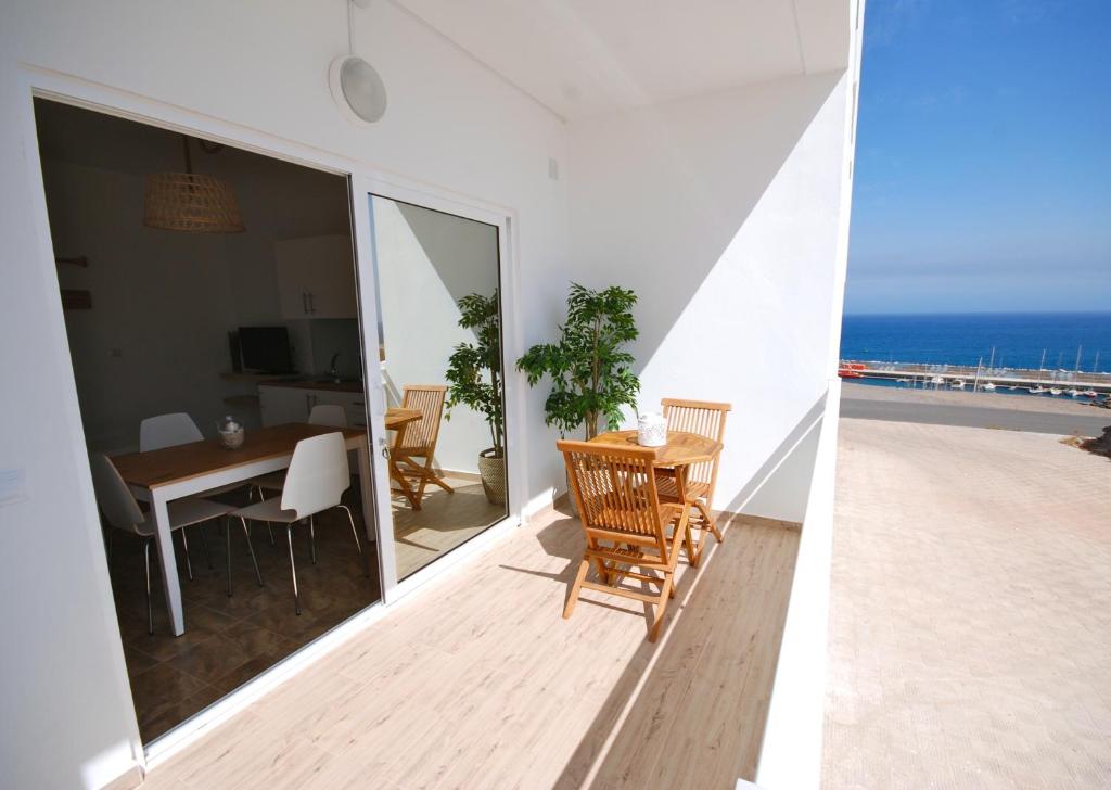 a balcony with a table and chairs and the ocean at El Aceitun Beach Holiday Homes in Gran Tarajal