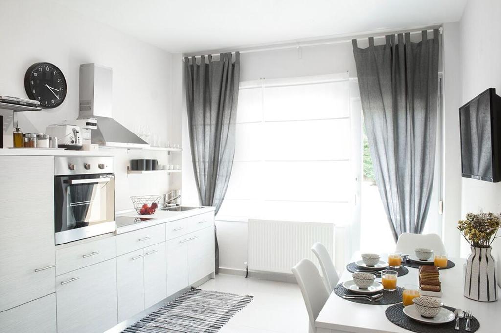 a kitchen with white cabinets and a table and a window at Sole e mare in Órmos