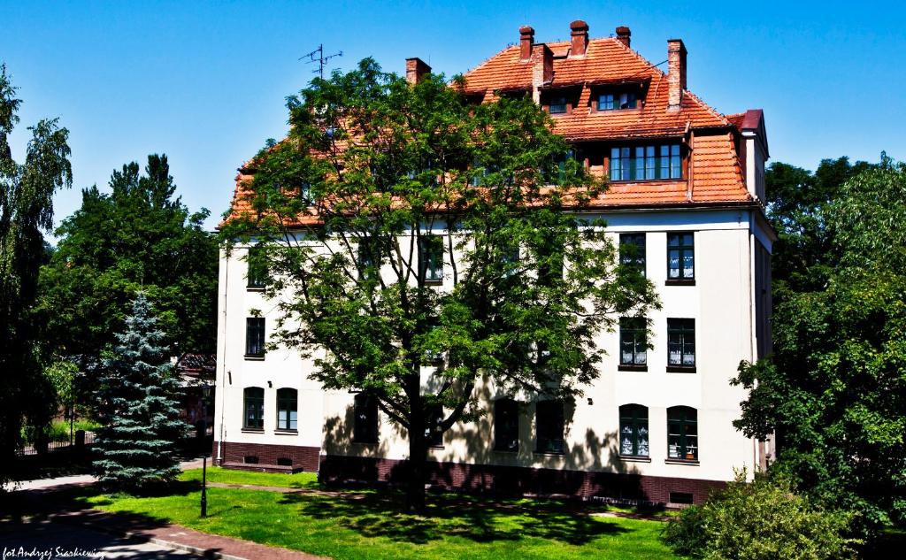 a large white house with a tree in front of it at DS Cztery Pory Roku in Gdańsk