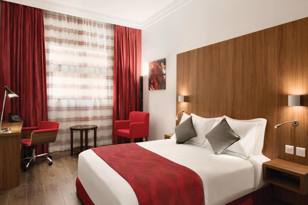 una camera d'albergo con letto e scrivania di Ramada Encore Al Khobar Olaya a Al Khobar