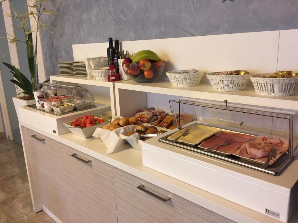 a kitchen with shelves with food on them at Apart Hotel Atlantic in Grado