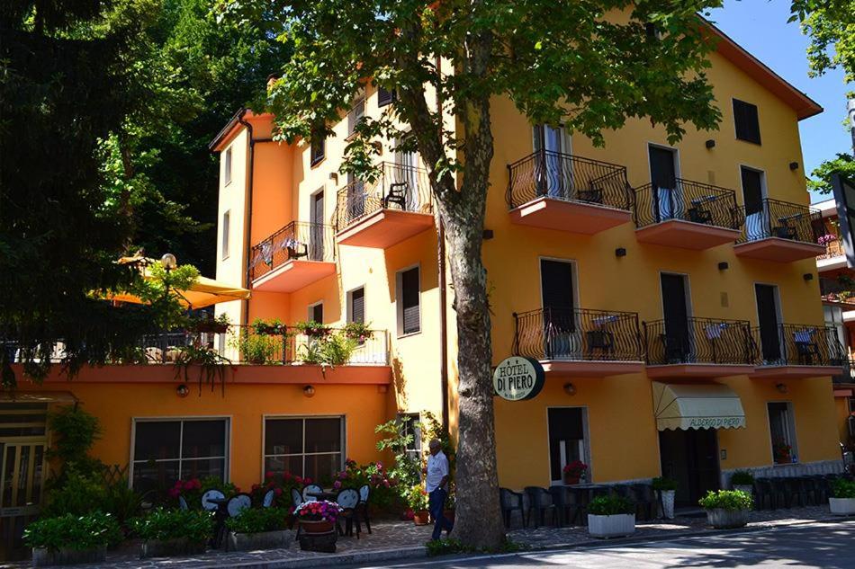 an orange building with a tree in front of it at Albergo Di Piero in Caramanico Terme