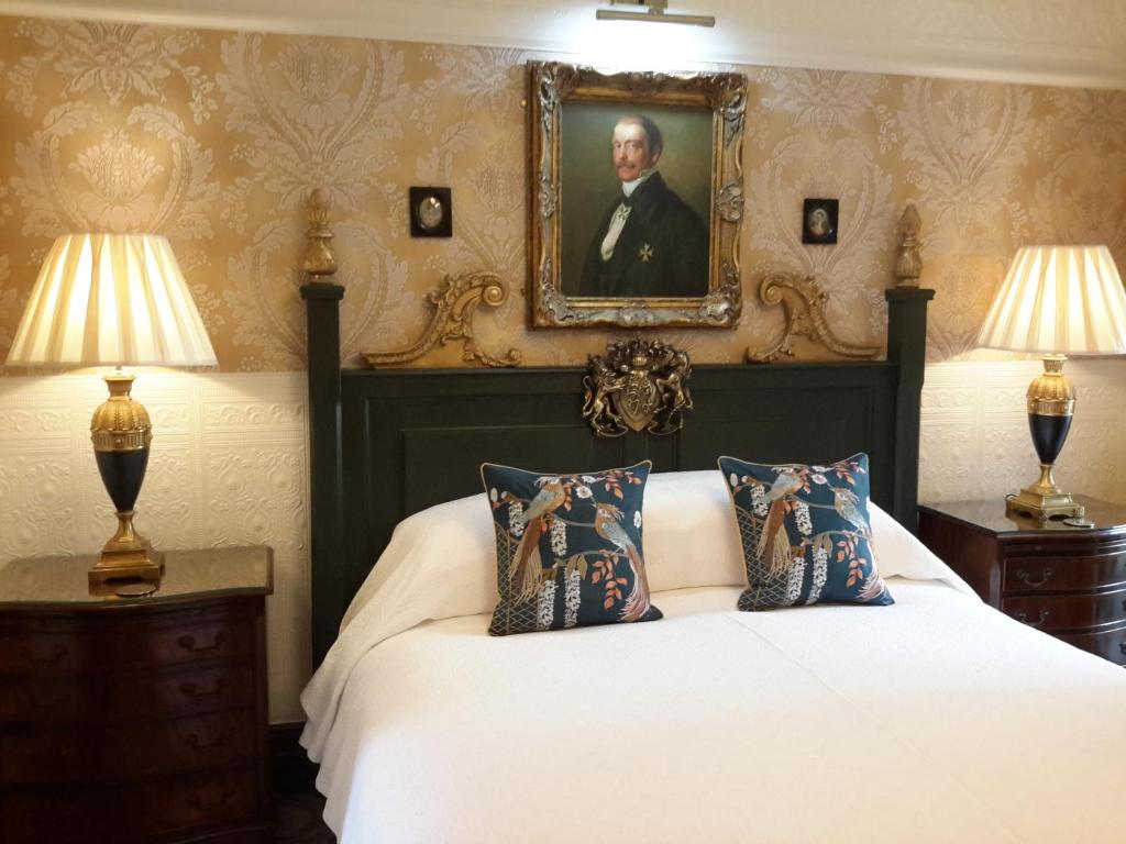 a bedroom with a bed with a portrait on the wall at The Lonsdale in Blackpool