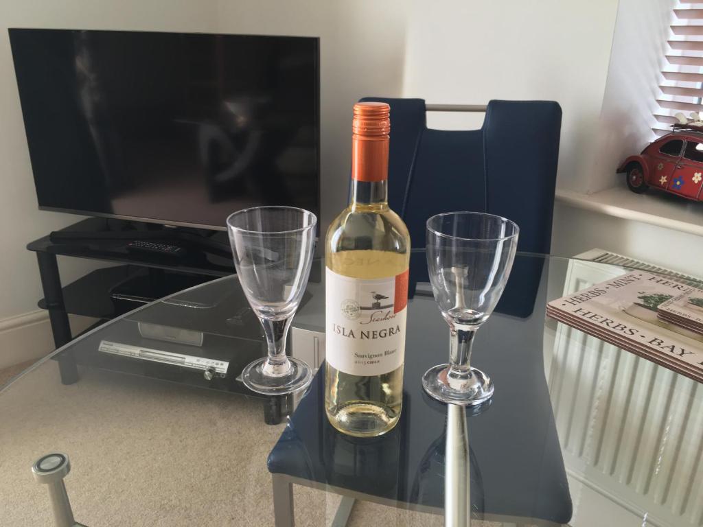 a bottle of wine and two wine glasses on a table at Southover Beach in Woolacombe