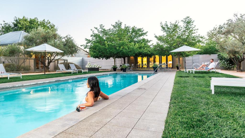 a little girl sitting next to a swimming pool at Duchamp Hotel - Downtown Healdsburg in Healdsburg