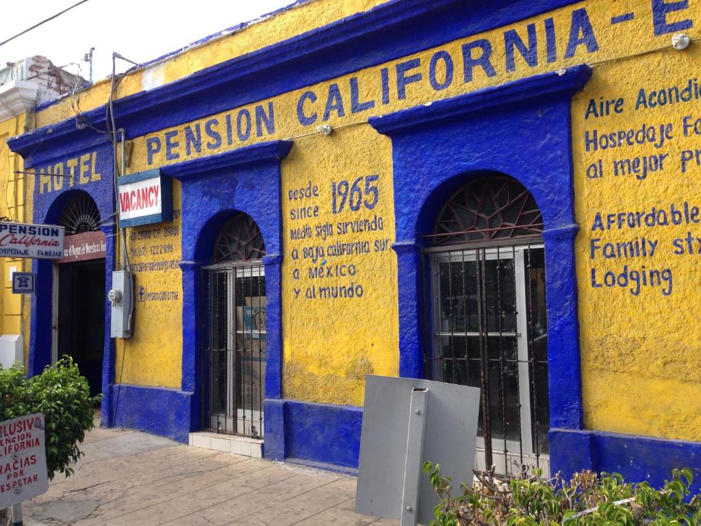 a building with a blue and yellow facade at Pension California in La Paz