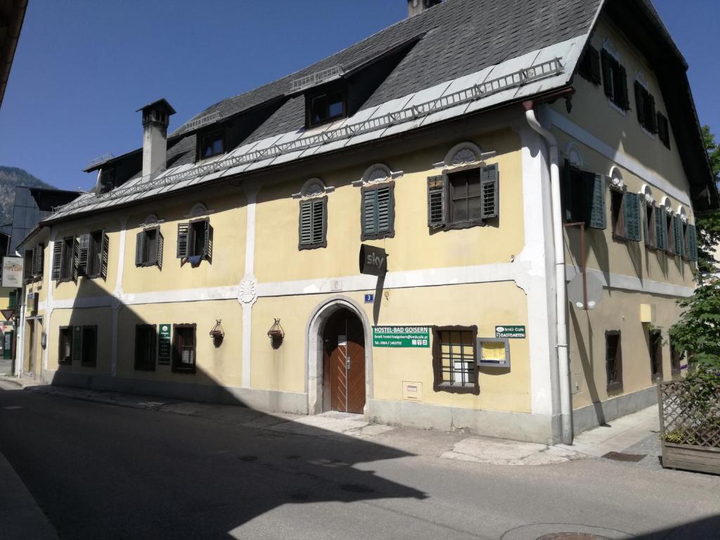 ein gelbes Gebäude mit einer Tür in einer Straße in der Unterkunft Hostel Bad Goisern in Bad Goisern