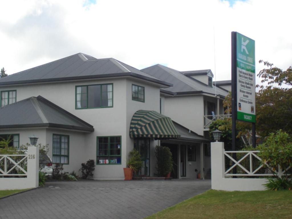 una casa blanca con un cartel delante en Karaka Tree Motel, en Taupo