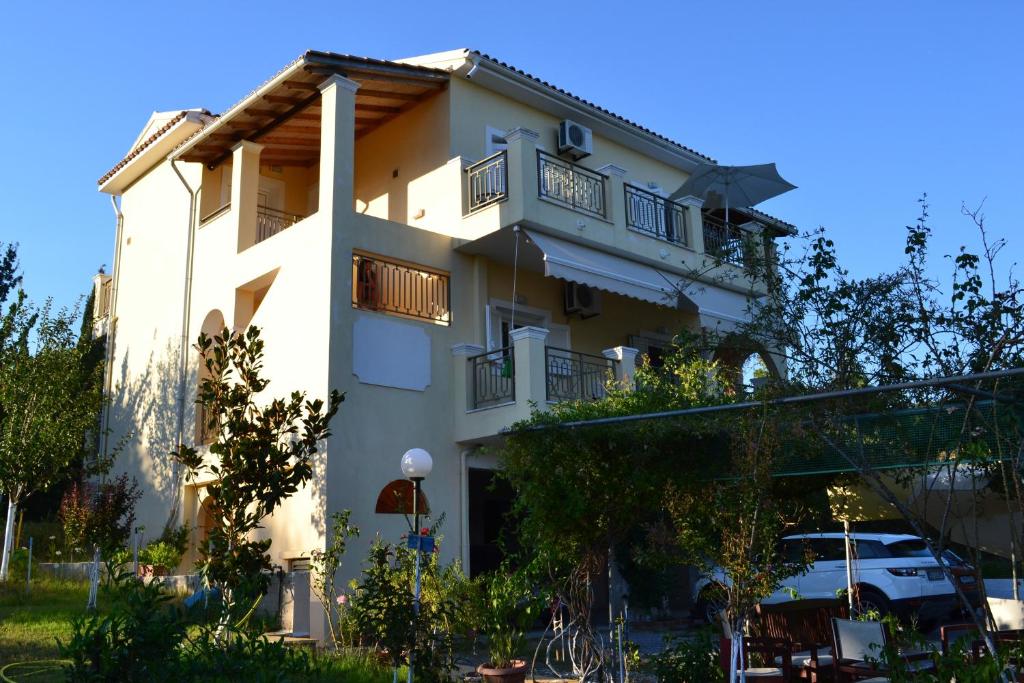 Un grand bâtiment blanc avec balcon est disponible. dans l'établissement Scorpios Apartments, à Dassia