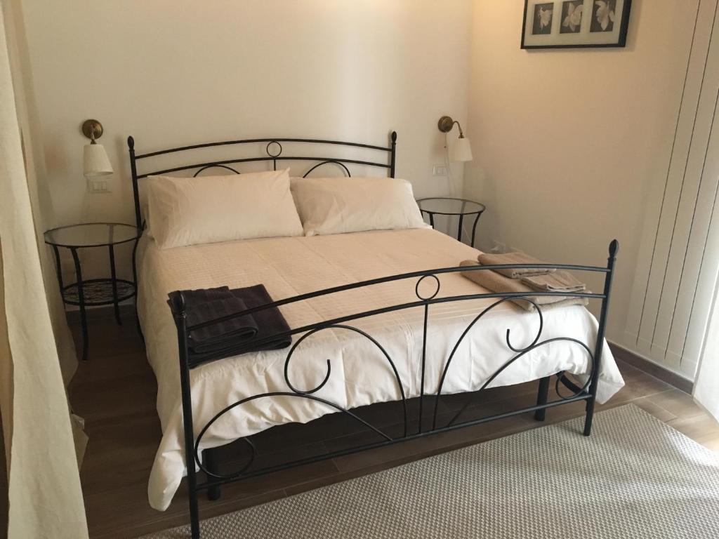 パレルモにあるButera Apartmentのベッドルーム1室(黒いベッド1台、白いシーツ、枕付)