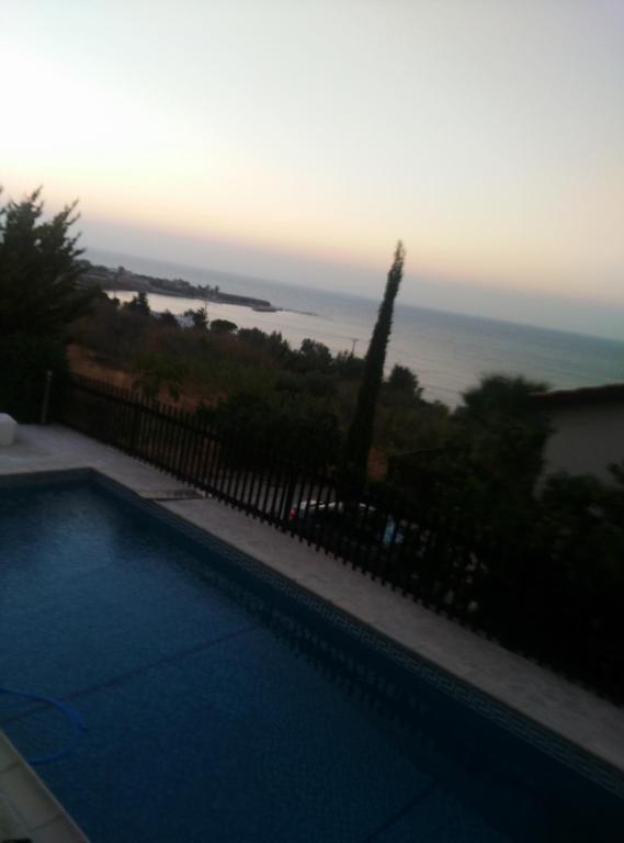 a swimming pool with a view of the ocean at Pomos Harbourbiew Villa in Pomos