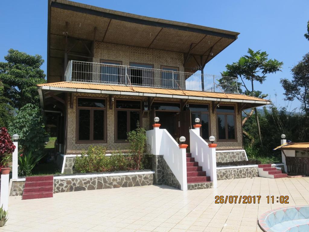 a house with a balcony on top of it at Salak Sunrise Homestead in Bogor