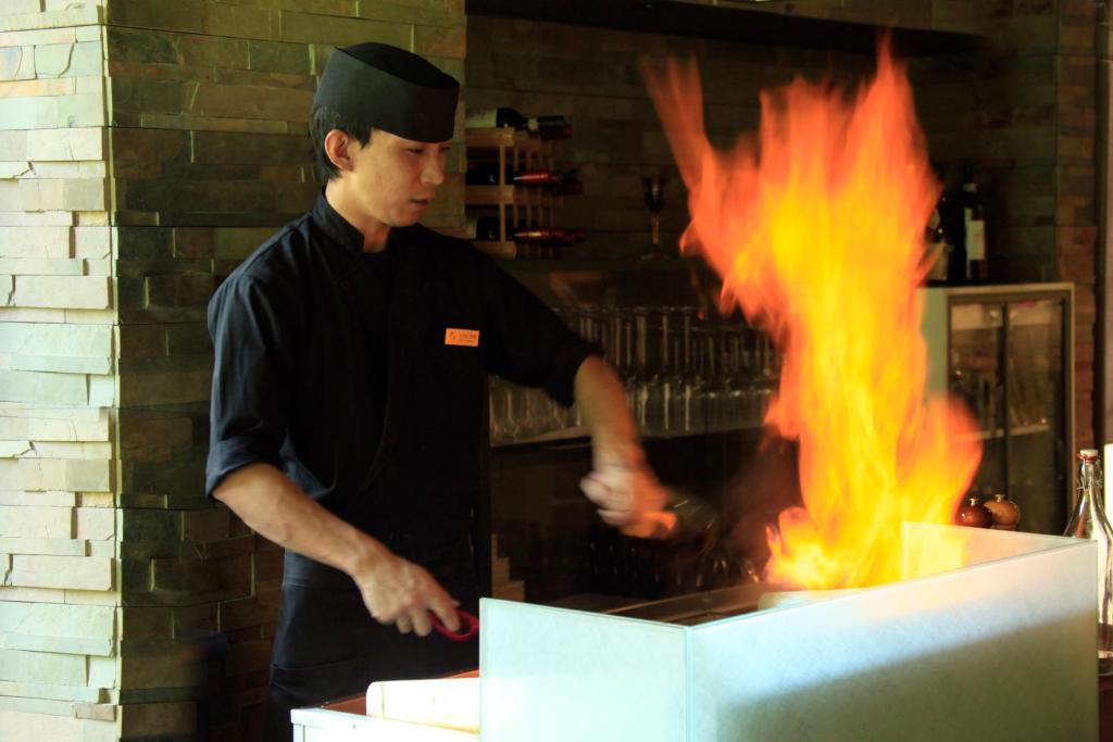 a man standing in front of a stove with flames at Hakone Fuga (Adult Only) in Hakone