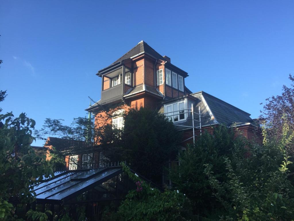 uma casa grande no topo de uma colina em Korfuvej.rent.a.room em Copenhague