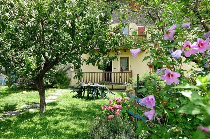 una casa con una mesa de picnic en un patio con flores en CASA SEEZ Alloggio ad uso turistico VDA SAINT-PIERRE n 0002, en Saint-Pierre