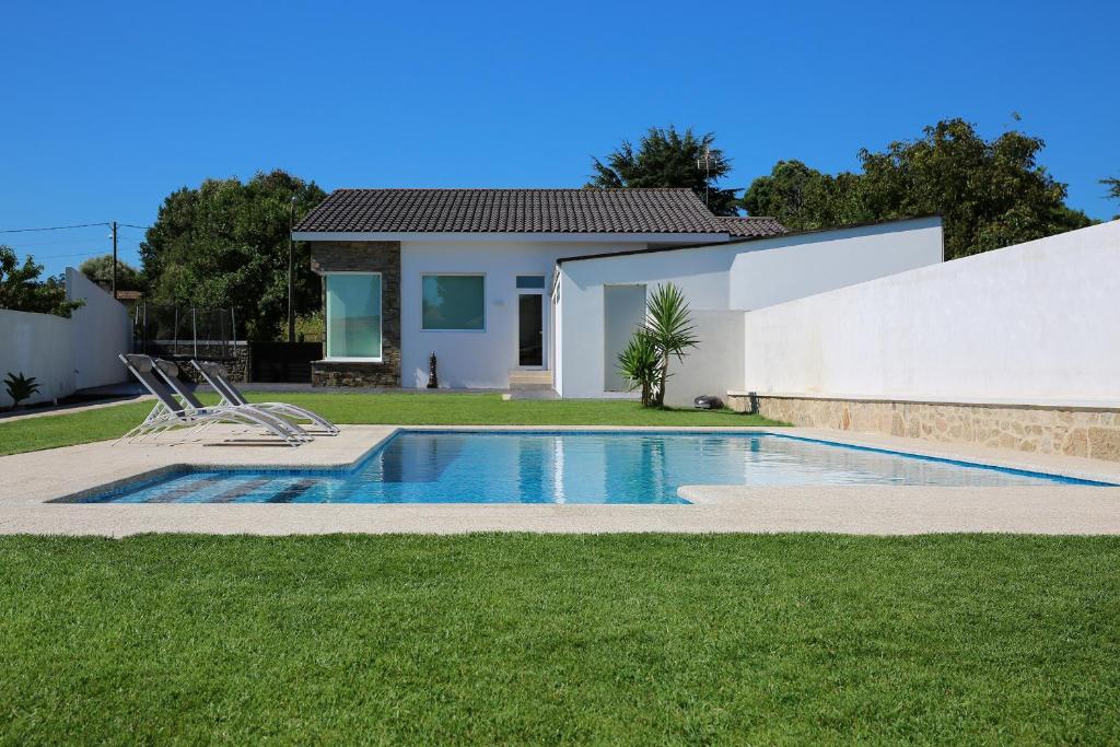 une maison avec une piscine dans une cour dans l'établissement Casa rural con piscina Viña de Millan, à O Grove