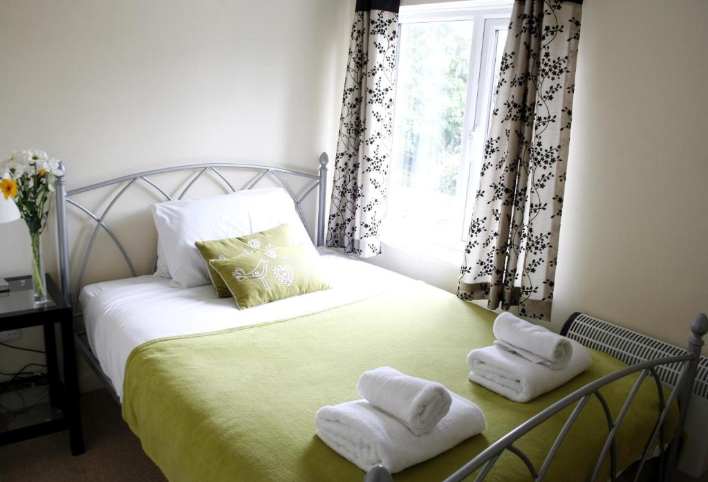 sypialnia z łóżkiem z dwoma ręcznikami w obiekcie Walkers Court By Treetop Property w mieście Cirencester