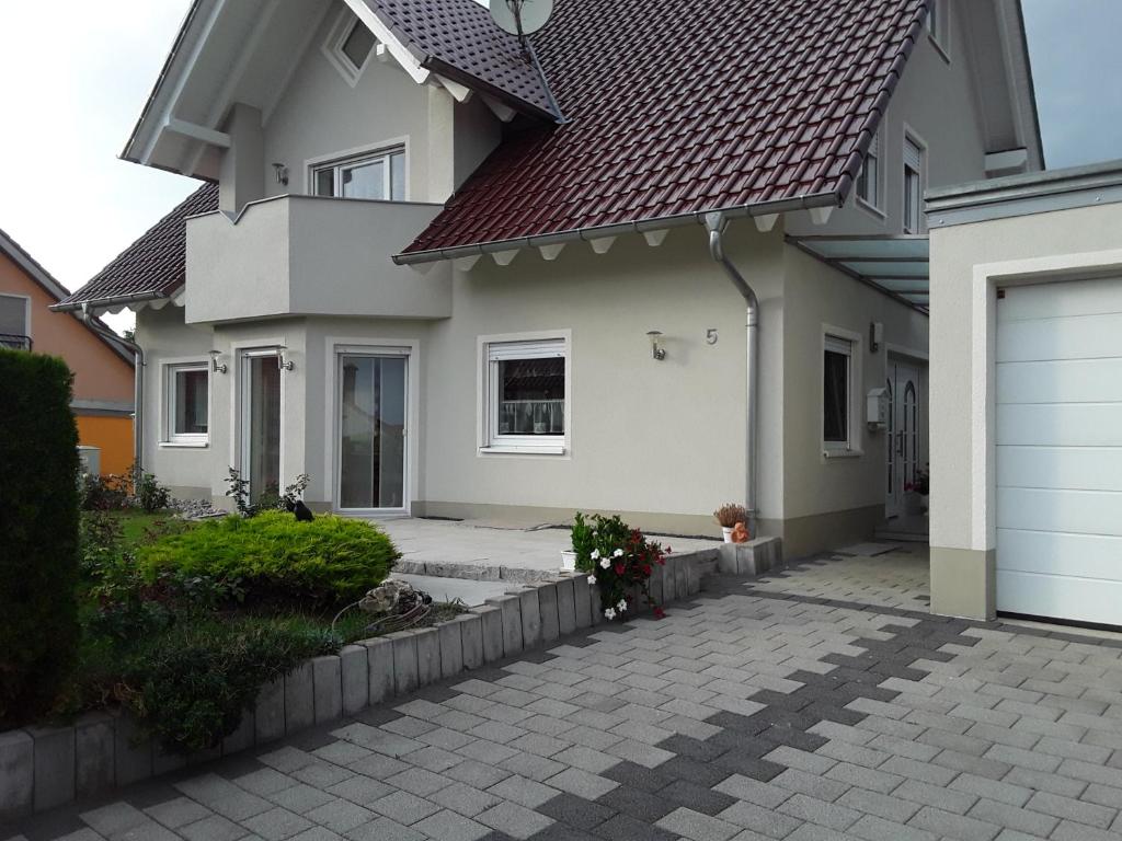 a white house with a red roof and a driveway at Ferienwohnung Mayer in Kirchheim am Ries