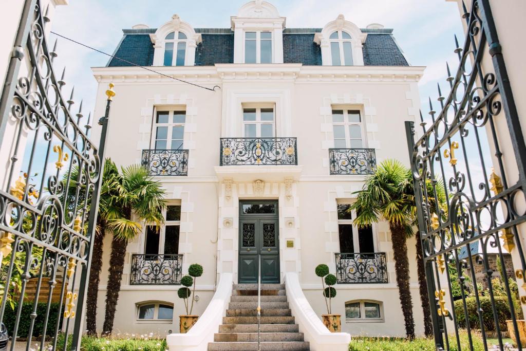 una casa bianca con una porta verde e scale di L'Hôtel Particulier Ascott a Saint Malo