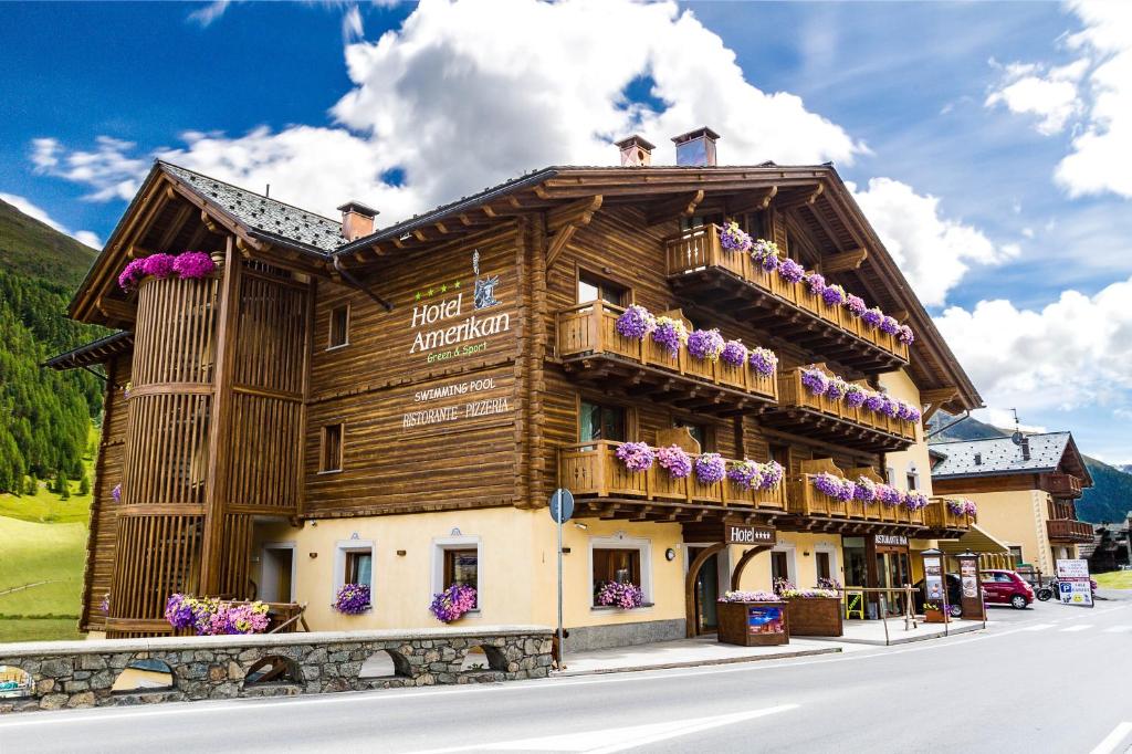 a wooden building with flowers on the balconies at Hotel Amerikan in Livigno