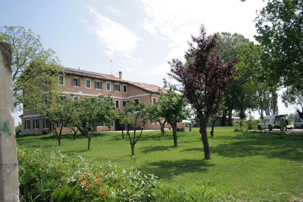 ein Gebäude mit einem Hof mit Bäumen davor in der Unterkunft Locanda Antico Fighèr in Musile di Piave