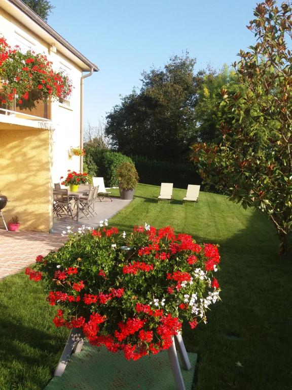 um jardim com um ramo de flores vermelhas num quintal em Ma maison fleurie proche aéroport, Groupama Stadium,Eurexpo em Janneyrias
