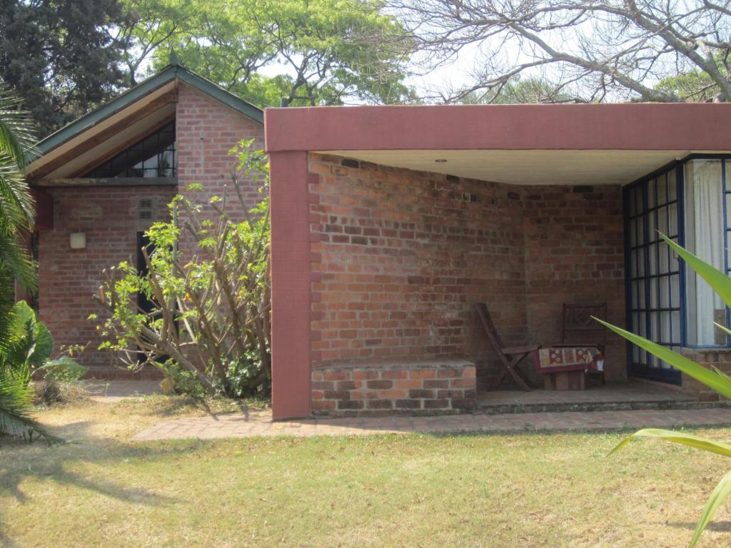 a brick building with a fireplace in a yard at Weaver Cottages in Harare