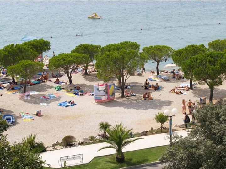 a crowd of people on a beach near the water at Apartment Dora in Crikvenica