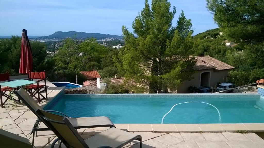 a swimming pool with two chairs and a table at Le Baou in Toulon