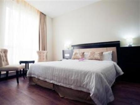ein Schlafzimmer mit einem großen weißen Bett und einem Stuhl in der Unterkunft Hotel S Damansara in Kuala Lumpur