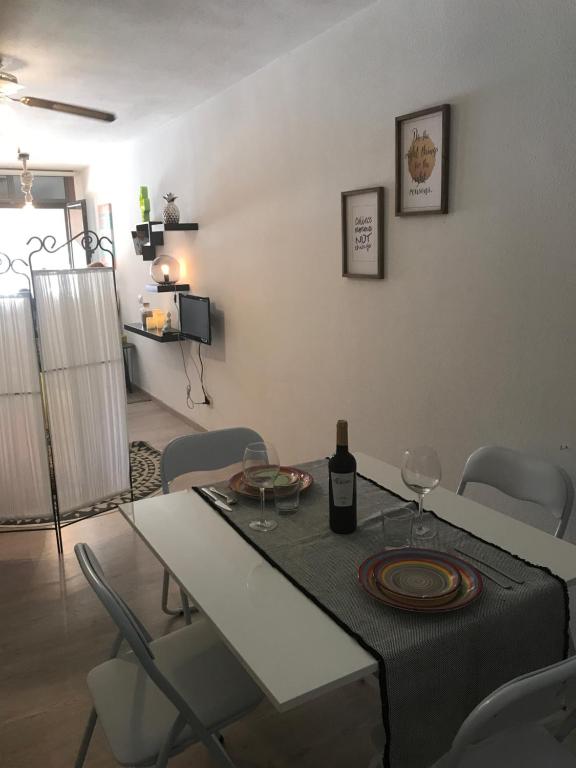a dining room with a table with a bottle of wine at Las Olas in El Médano