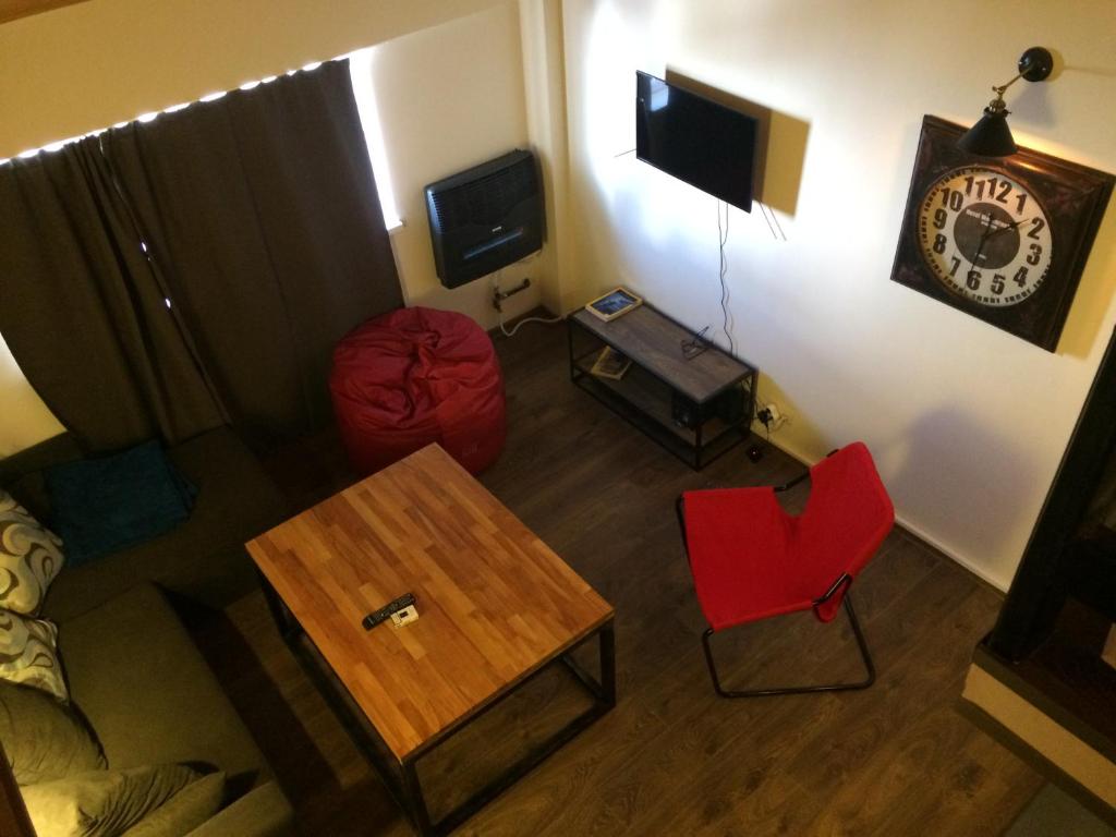 a living room with a red chair and a table at Iceberg Loft in Gudauri