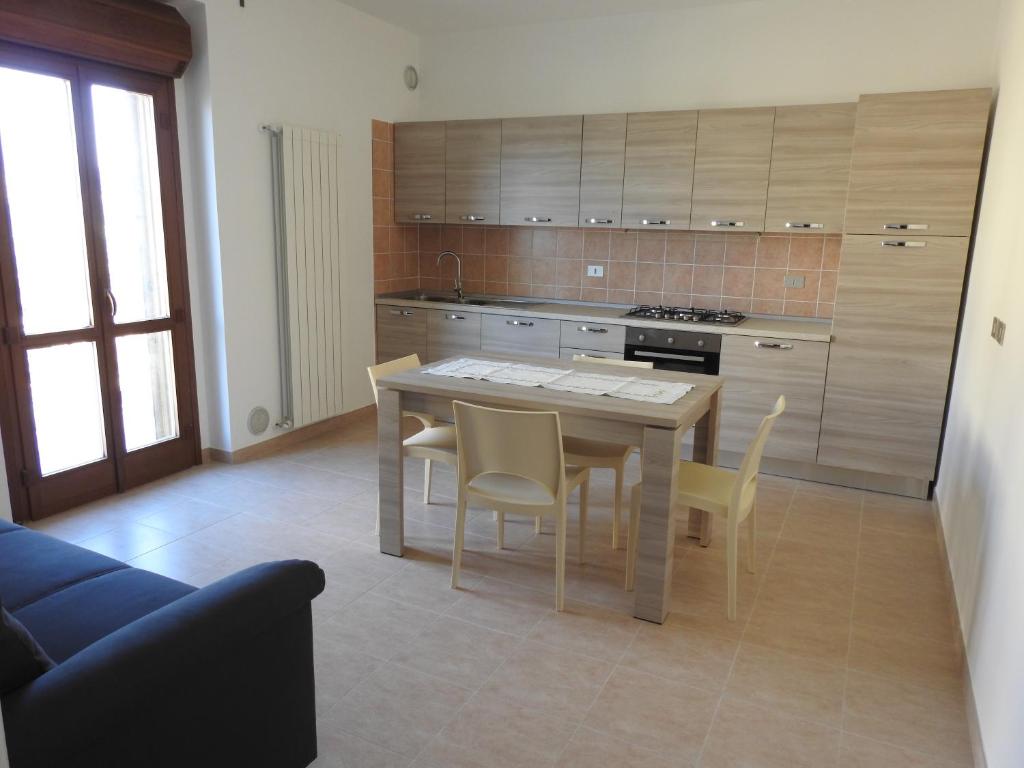 eine Küche mit einem Tisch und Stühlen im Zimmer in der Unterkunft Soggiorno "Ulivi" in Altino