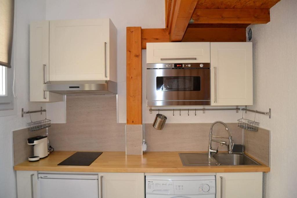 une cuisine avec un évier et un micro-ondes dans l'établissement Aoustin, à Nice