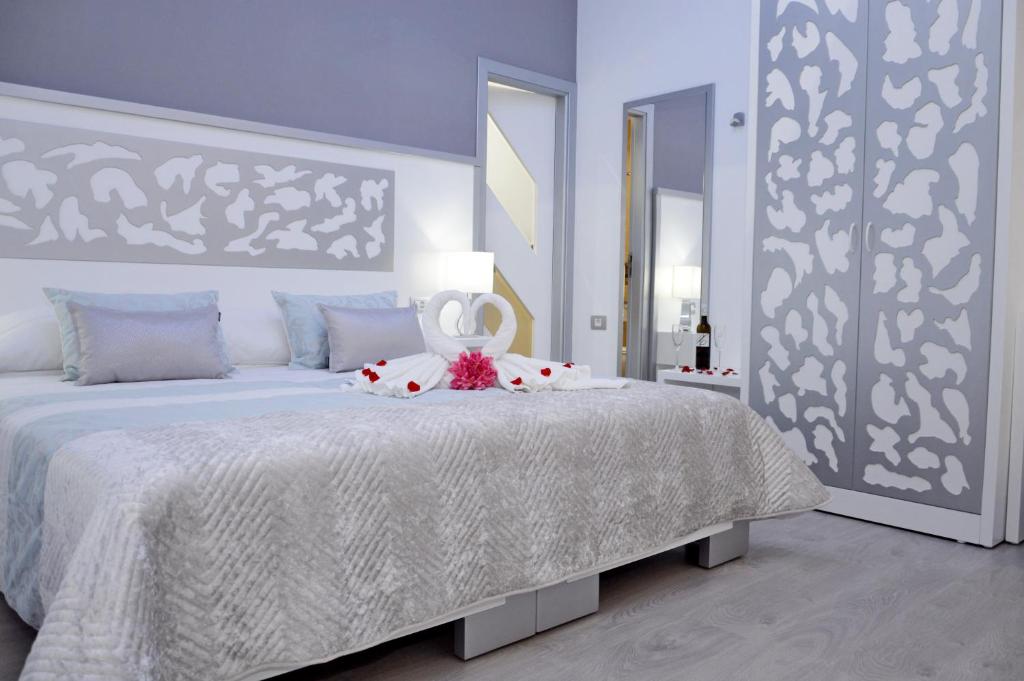 a bedroom with a white bed with a white bedspread at Hotel Drago San Antonio in Icod de los Vinos