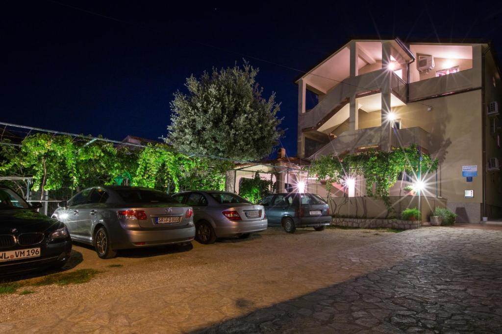 a group of cars parked next to a building at night at Šanić Apartments 518 in Lopar