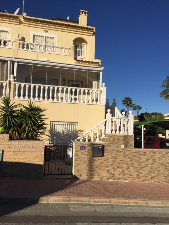 a large yellow building with a white balcony at KaSandra in Rojales