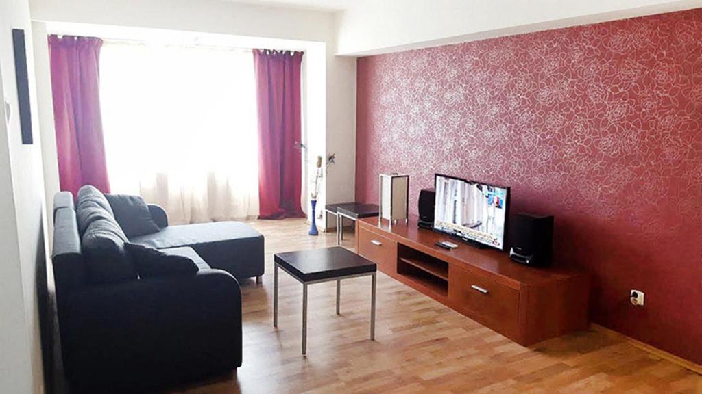 a living room with a couch and a tv at Perla Dorobanti Apartment in Bucharest