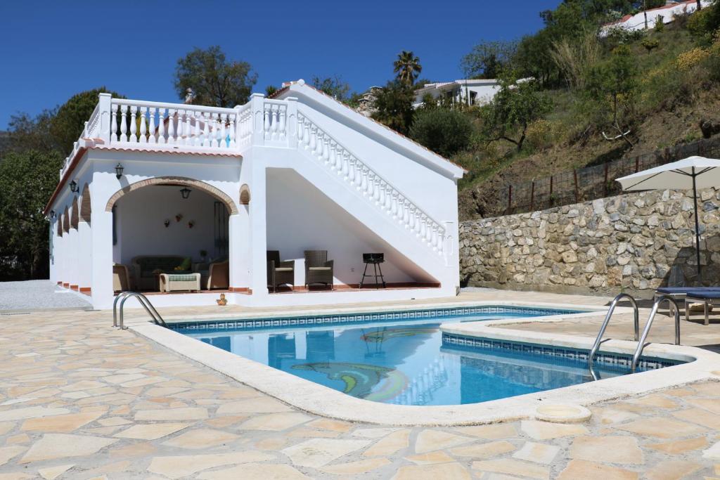 een villa met een zwembad en een huis bij Casa los Almendros in Canillas de Albaida