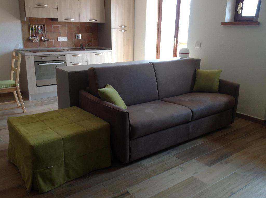 a living room with a brown couch and a stool at Cianfuran 2 in Bardonecchia