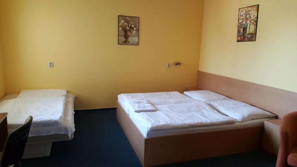 A bed or beds in a room at Lehár panzió