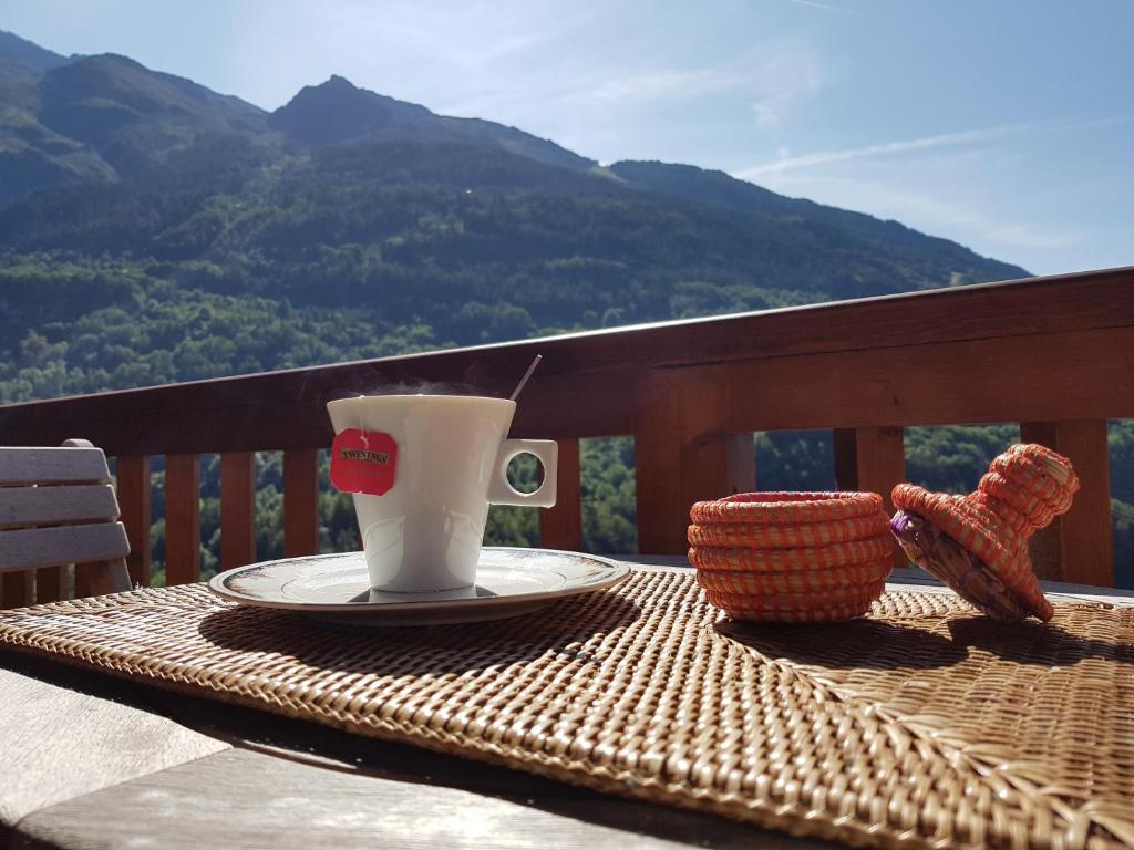 a table with a cup of coffee on top of a balcony at Arpege Des Neiges in Sainte-Foy-Tarentaise