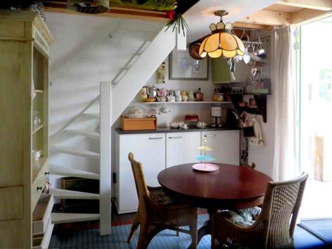 una cocina con mesa y sillas y una escalera en B&B Vroomm, en Helvoirt