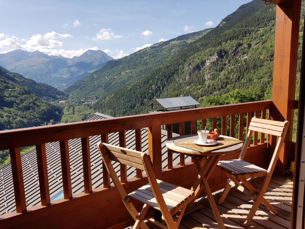 a table and chairs on a balcony with mountains at Arpege Des Neiges in Sainte-Foy-Tarentaise