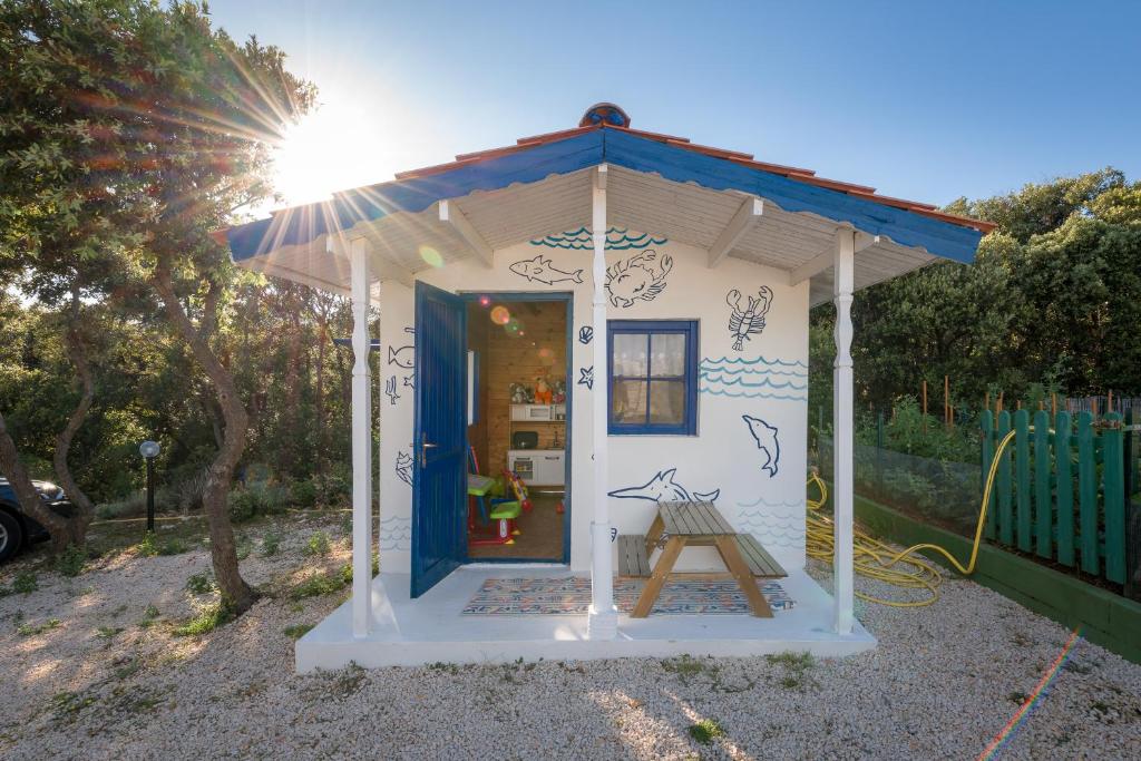 a small house with a blue door in a yard at Holiday Park Mandrice in Mandre