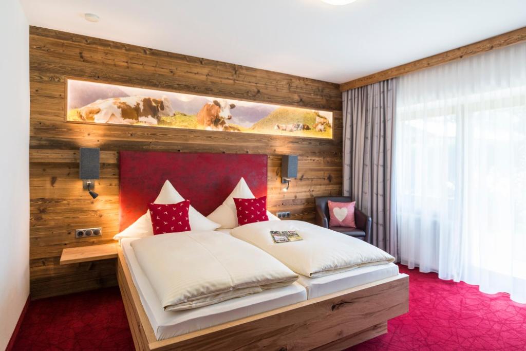 a bedroom with a bed with a wooden wall at Pension Wendelstein in Miesbach